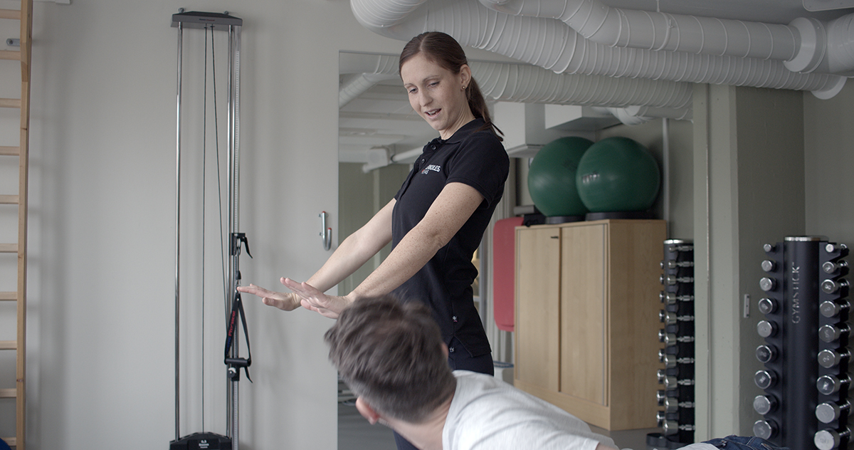 Foto: Fysioterapeuterna/Vingaland Kvinnlig fysioterapeut instruerar patient hur en rörelse ska utföras.